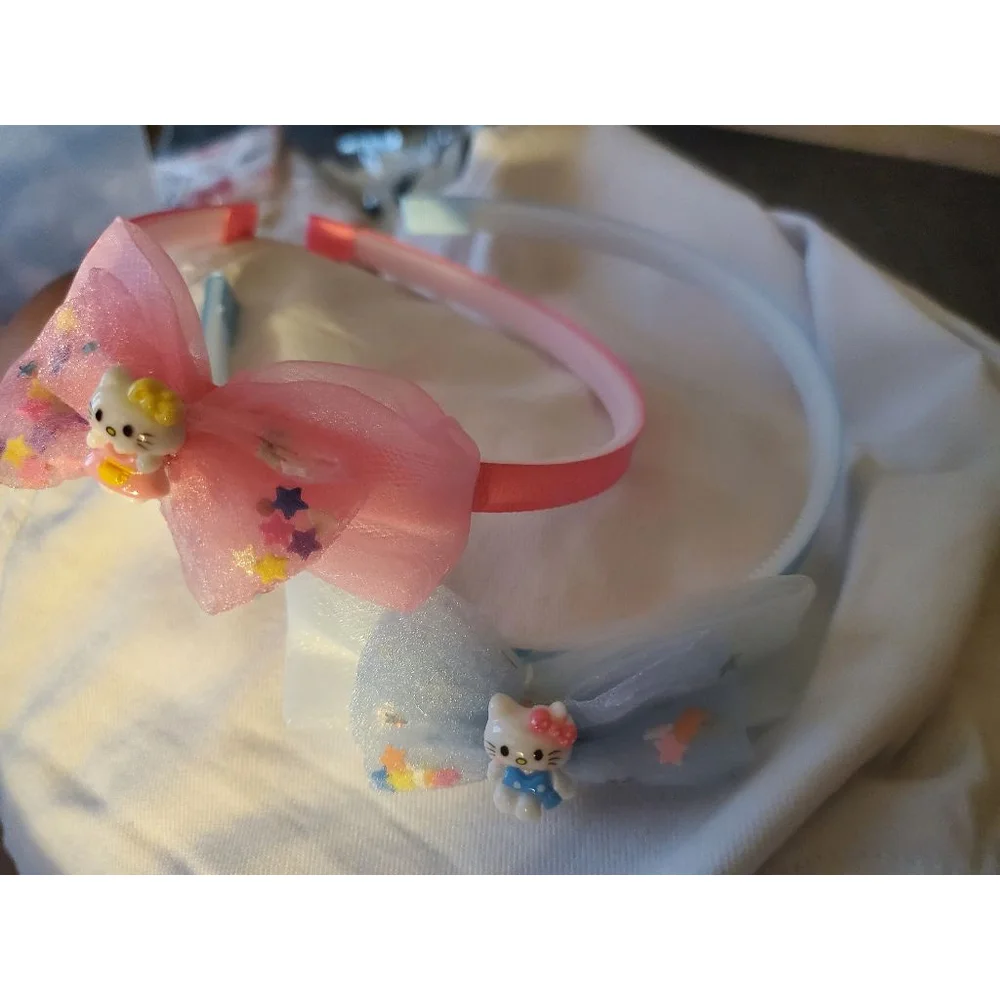 Four Hello Kitty headbands with small figurine